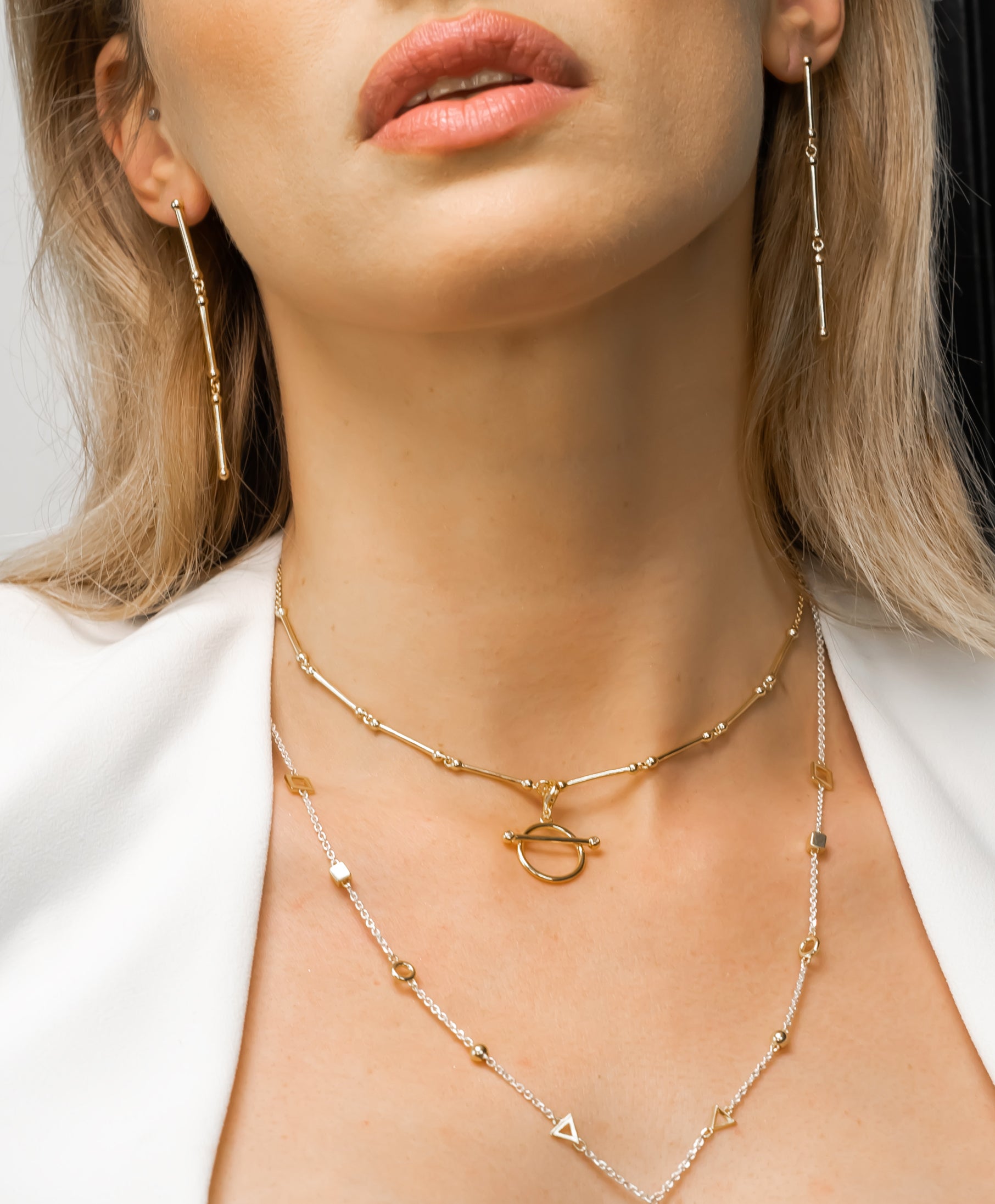 Blond-woman-wearing-Singula-jewelry-rond-choker-gold-emeralds