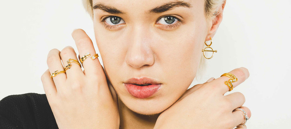Singula-jewelry-woman-wearing-gold-silver-rings-diamonds-earrings